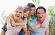 couple giving two young children piggyback rides